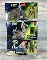 Front view of the three boxed Star Wars Power of the Force Tatooine lot sets: Dewback Sandtrooper, Ronto Jawa, Jabba the Hutt Han Solo.