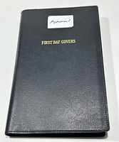 Black binder album labeled 'First Day Covers' with an 'Airmail!' sticker on the front.