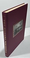 Hardcover maroon book with gold lettering spine and black and white photo inset on cover