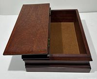 Top-open view of vintage wooden lap box showing interior lined with felt and hinged lid.