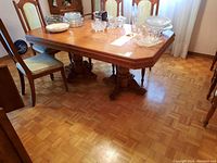 Dining table showing top surface with various dishes on it, displaying the wood finish and minor scratches.