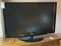 Front view of the 42 inch LG 42LG630 flat screen TV powered off, showing black bezel and TV stand.