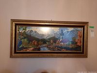 Front view of the framed needlepoint art showing the full landscape scene