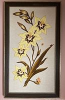 Full view of framed needlework floral artwork showing the entire design and frame