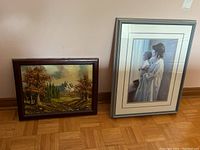 Two framed artworks side by side; one is a matted and framed print under glass, the other a framed canvas painting.