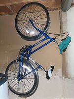 Side view of blue Raleigh bicycle showing frame, tires, and handlebars.