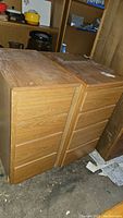 Two wooden cabinets side by side showing front and top surfaces with visible wear and drawer fronts.