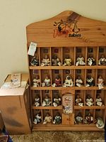 Full view of the wooden display case with each Daddy's Babies doll in individual compartments labeled A-Z.