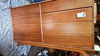 Dresser laying on its side showing front with multiple wooden slat drawers.