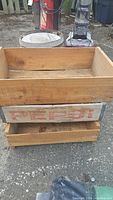 Wood boxes stacked outside with visible 'PEPSI' marking on one wooden box