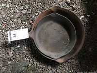 Two Griswold cast iron skillets, one nested inside the other, showing heavy rust and dirt on surfaces.
