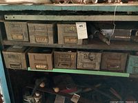 Wide view of upper inside level cabinet showing metal storage boxes, some drawers open revealing contents like hand tools and hardware.