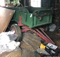 Front angle showing green wooden bed and red metal frame
