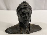 Front view of cast metal bust showing detailed facial features and headwear.