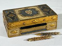 Decorative wooden box and antique pen and pencil displayed from the front