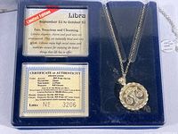 Original box contents showing Libra Zodiac pendant with chain, Certificate of Authenticity, and Libra description card.
