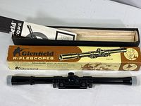 Full view of Glenfield Model 200 riflescope laid in front of original box and manual in box.