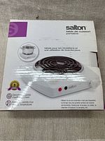 Box packaging showing Salton electric hot plate with image, text and specifications on the box.