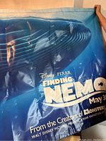 Front side of the vinyl poster showing a large blue whale underwater with the Finding Nemo title and movie release date.