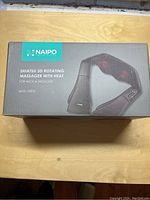 Packaged box showing Naipo Shiatsu 3D rotating massager with heat for neck and shoulder, model MGS-150DC.