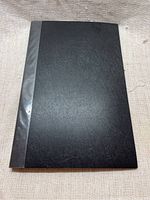 Closed black portfolio showing textured cover and black spine