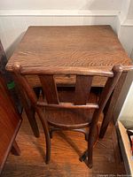 View of the chair from the back showing curved backrest with three vertical slats and solid wood seat.