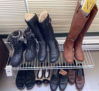 Full display of ladies boots and shoes with white wire rack, showing all footwear included in the lot