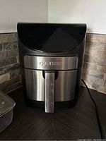Front view of Gourmia GAF798 air fryer showing stainless steel and black plastic body, handle and Gourmia branding.
