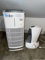 Front view of Cuisinart air purifier and Life brand table humidifier side by side on carpet.