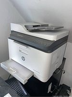 Full view of HP color laser multifunction printer showing scanner, control panel, and paper tray.