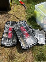 Three 22 inch Husky black connect organizers with clear lids on grass, showing internal compartments with assorted hardware.