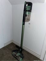 Full view of the Shark Rocket Pro vacuum upright with green and black color, showing the dust canister and stick.