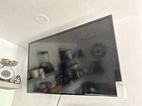 Front view of the 40 inch black flat-screen Element television mounted on the wall.