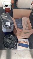 Overview of camping gear including two sleeping bags, coolers, and cardboard boxes with camping accessories.