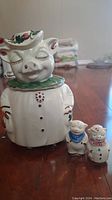 Full view of the pig-shaped cookie jar along with matching salt and pepper shakers.