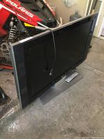 LG 42-inch TV with base stand seen from side angle on concrete floor.