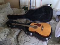 Open hard-shell case with Cort L500C acoustic guitar inside