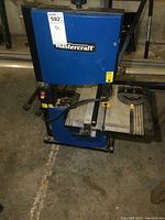 Front view showing blue casing and Mastercraft logo with base and table