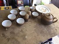 Complete set including 6 cups, 6 plates, teapot, cream and sugar bowls, salt and pepper shakers displayed on table.