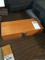 Closed wooden box case for Forstner bits placed on a wooden surface.