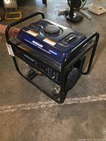 Side view of Mastercraft portable gas-powered generator showing blue tank and black metal frame on concrete floor.