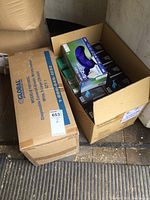 Photo of two large boxes; one labeled Global disposable coveralls size XL, the other open showing boxes of gloves inside including a Microflex glove box on top