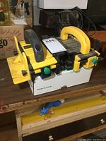 Two assembled GRR-Ripper units with yellow bases, ergonomic black handles, and green knobs, sitting on a wooden surface.