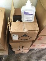 Photo of one 1L foaming hand sanitizer bottle placed on top of closed cases to show bottle design and label.