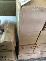 Stacked cardboard boxes containing sealed cases of the sanitizer bottles.