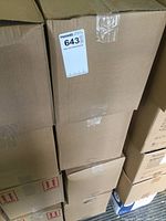 Stacked cardboard boxes containing cases of hand sanitizer bottles, unopened and sealed.