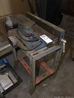 Side-angle view of the National 4 inch jointer mounted on a metal stand showing the belt motor and adjustment handle.