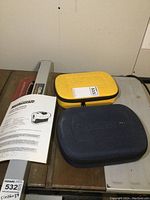 Two closed carrying cases for laser levels, one yellow, one dark blue with Mastercraft branding, and an instruction manual.