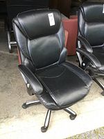 Front angle view of black leather office chair showing seat, backrest, armrests with minor wear visible on edges and cushions.