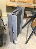 Folded Weather Tec ramp standing upright against a wall, showing the outer plastic side and bottom support feet